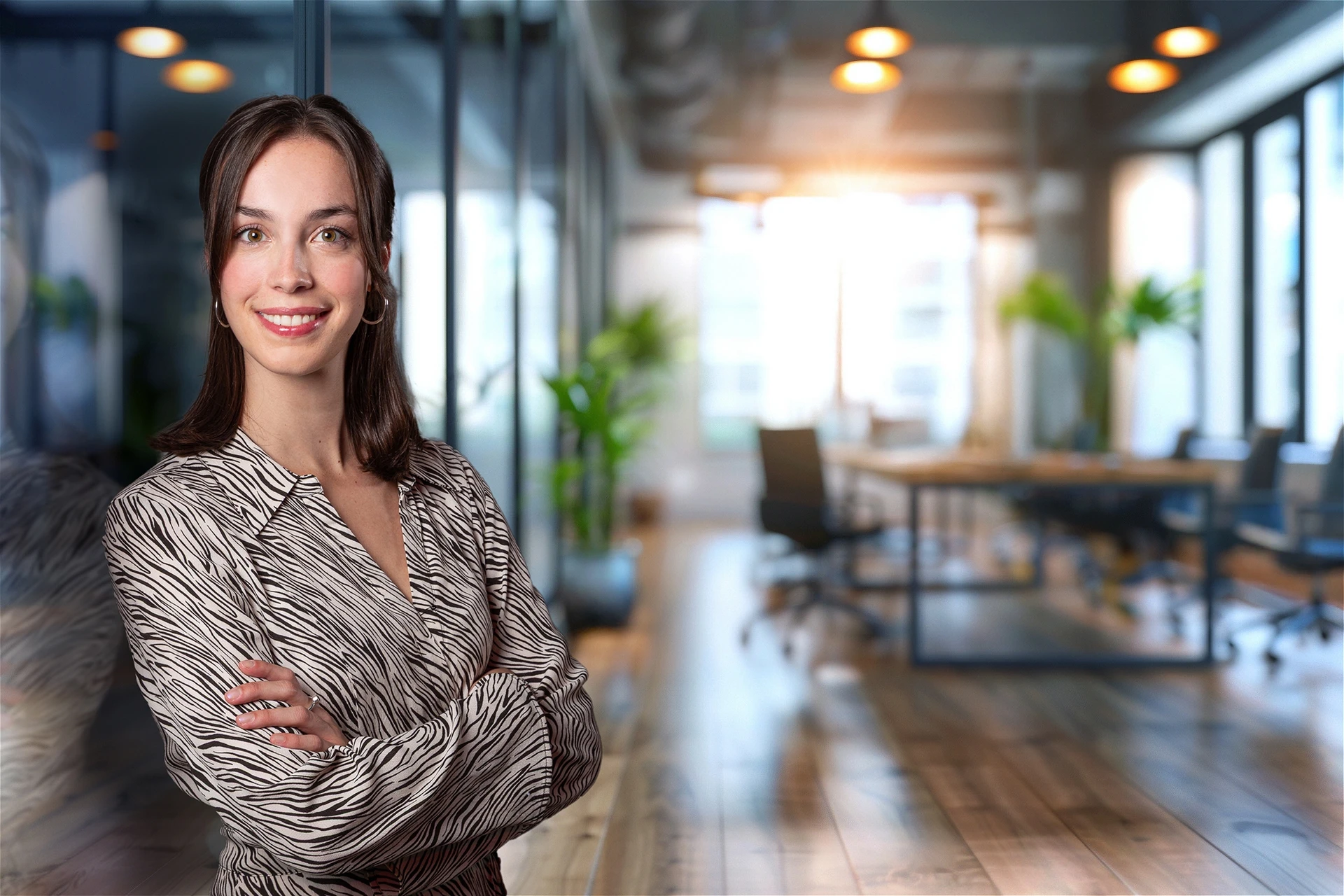 Businessportrait einer Frau in gemusterter Bluse in einem hellen Innenraum