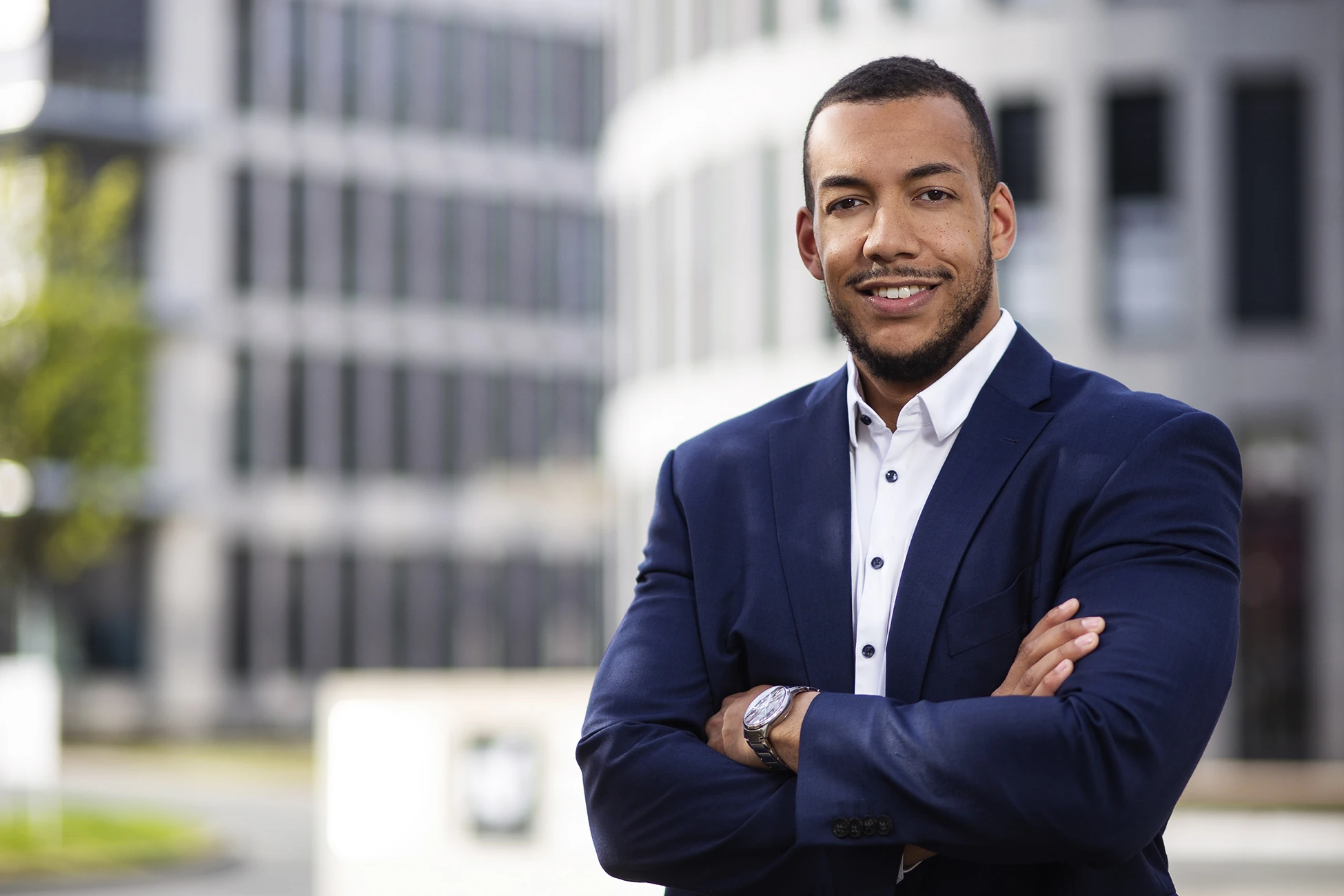 Businessportrait eines Mannes im blauen Sakko vor einer modernen Fassade