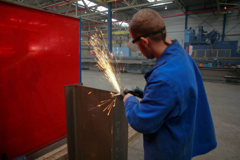 Mitarbeiter bei der Metallbearbeitung mit Funkenflug in einer Werkhalle