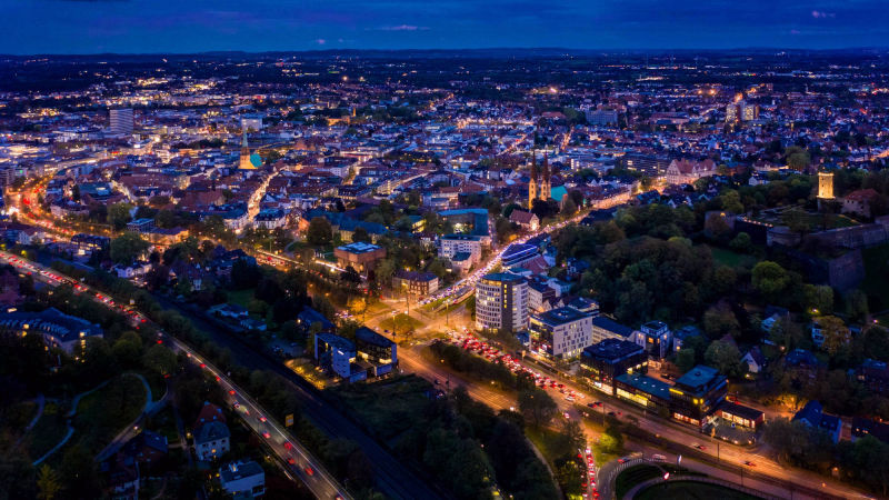 Luftaufnahme einer Stadt mit beleuchteten Straßen bei Nacht